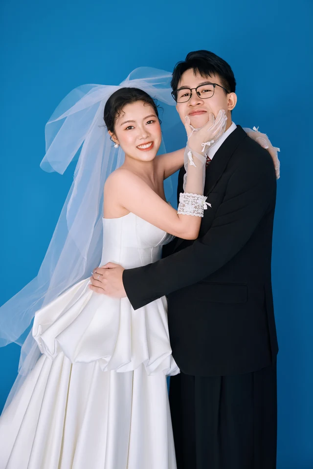 两位新人在蓝色背景前相拥